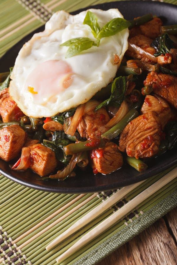 Thai Chicken with Basil, Green Beans and a Fried Egg on a Plate Stock