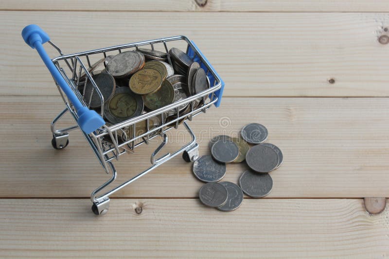 Thai Coin money in a shopping cart model. Thai Coin money in a shopping cart model on wooden broad background royalty free stock images Thai Coin money in a shopping cart model. Thai Coin money in a shopping cart model on wooden broad background royalty free stock images