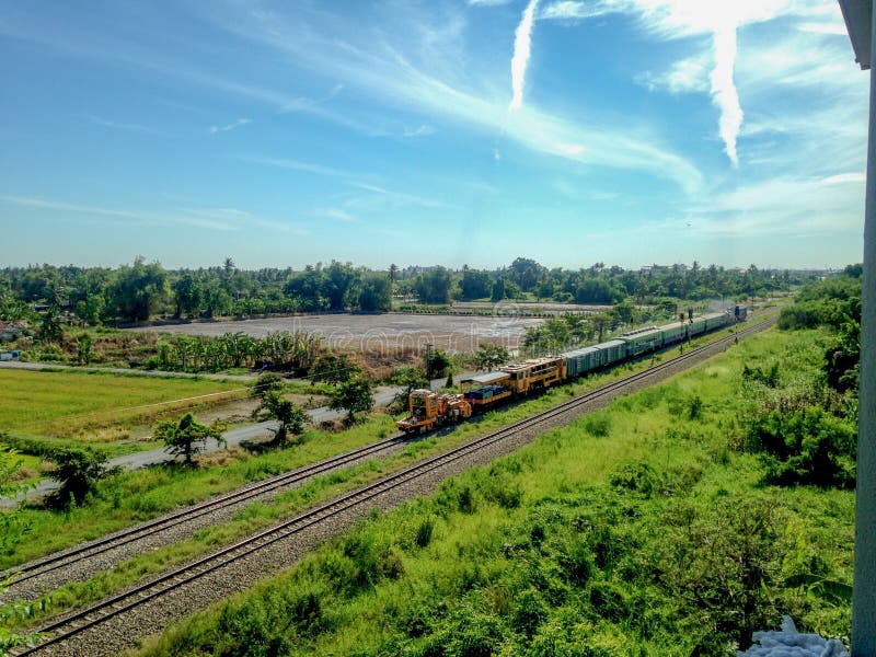 Thai diesel engine locomotive drives on the railway and pull the railroad track maintenance train and passenger bogies royalty free stock photo Thai diesel engine locomotive drives on the railway and pull the railroad track maintenance train and passenger bogies royalty free stock photo