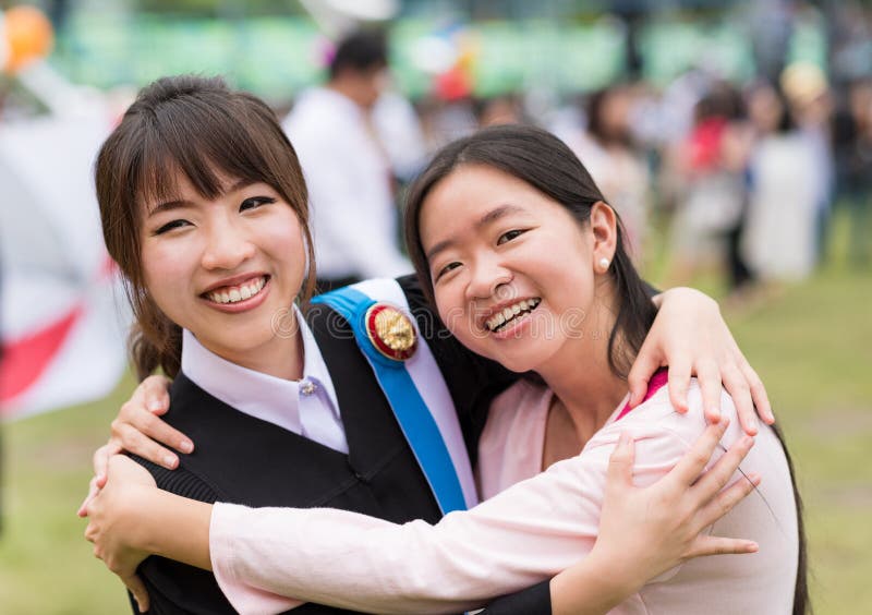 Thai girl is hugging her friend who graduated a master degree stock photography Thai girl is hugging her friend who graduated a master degree stock photography