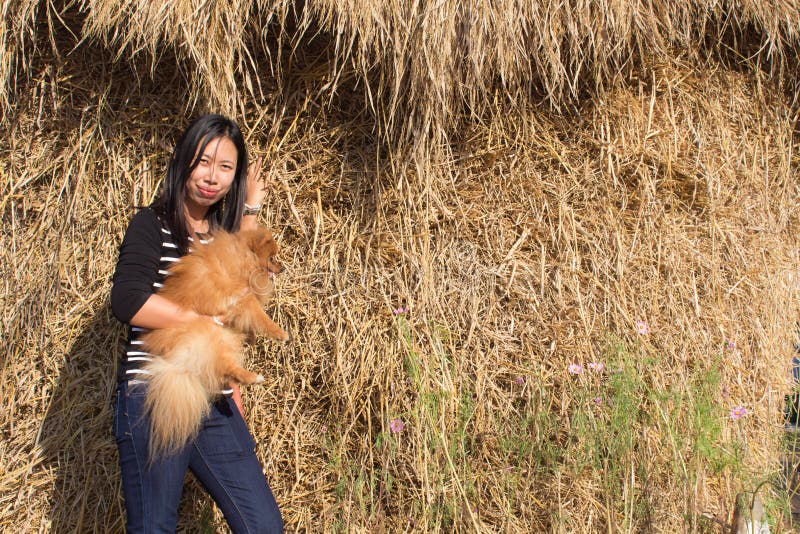 thai kvinna för stående och pomeranian med sugrör royaltyfri foto thai kvinna för stående och pomeranian med sugrör royaltyfri foto