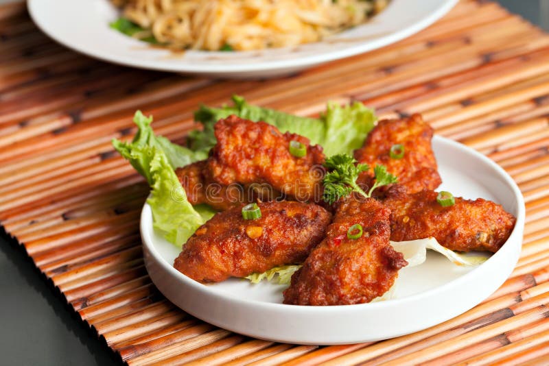 Thai style spicy chicken wings on a round white plate. Crispy diet stock images, royalty-free photos and pictures