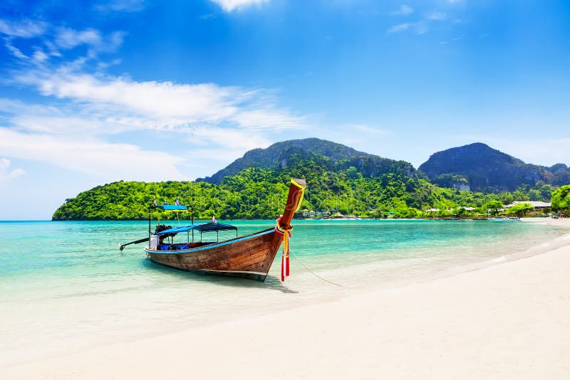 Thai traditional wooden longtail boat and beautiful sand beach