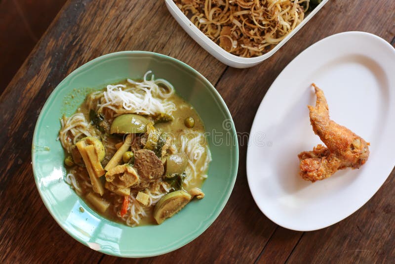 Thai Vermicelli Eaten And Chicken Curry Thai Tradition Food With Ingredients And Herbs On Wooden Background With Vintage Tone and stock photo Thai Vermicelli Eaten And Chicken Curry Thai Tradition Food With Ingredients And Herbs On Wooden Background With Vintage Tone and stock photo