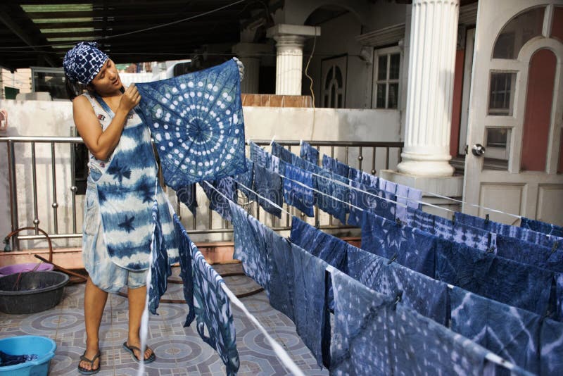 Thai women working Indigenous knowledge of thailand tie batik dyeing indigo color at outdoor on top of house at Thailand