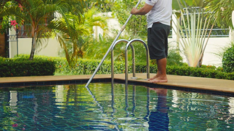 Thailand, Koh Samui, 2 december 2015. Worker man clean a swimming pool in resort.
