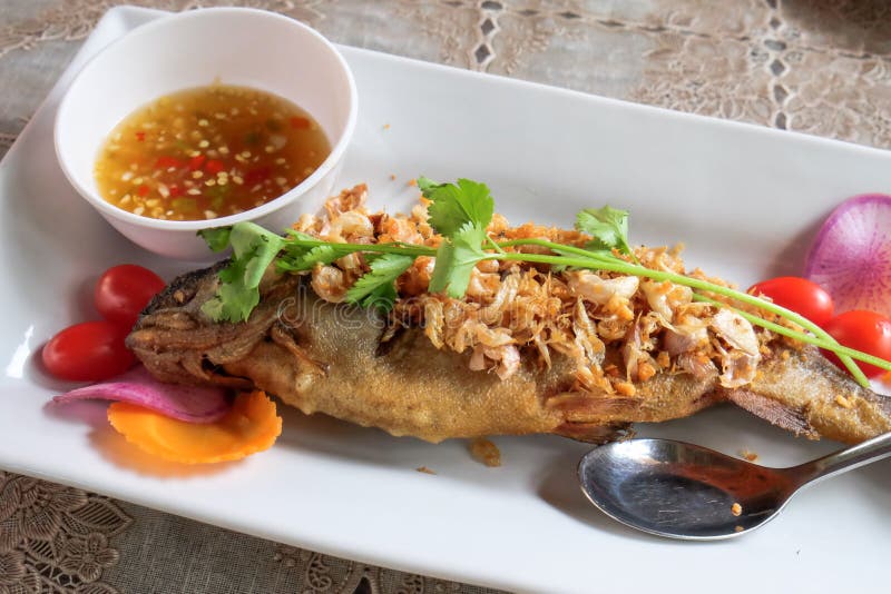 Thailändisches Lebensmittel, gebratene Fische mit Knoblauch und würzige Quelle