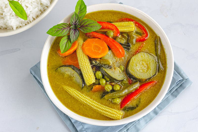 Thailändsk grön curry för strikt vegetarian med ris som garneras med thailändsk basilika royaltyfria bilder Thailändsk grön curry för strikt vegetarian med ris som garneras med thailändsk basilika royaltyfria bilder