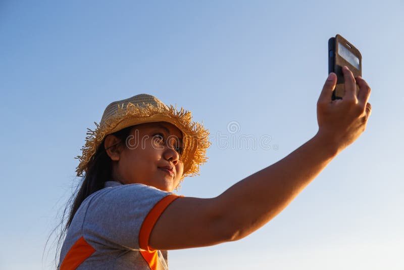 Thailändsk kvinna som använder smartphonen på stranden royaltyfri bild Thailändsk kvinna som använder smartphonen på stranden royaltyfri bild