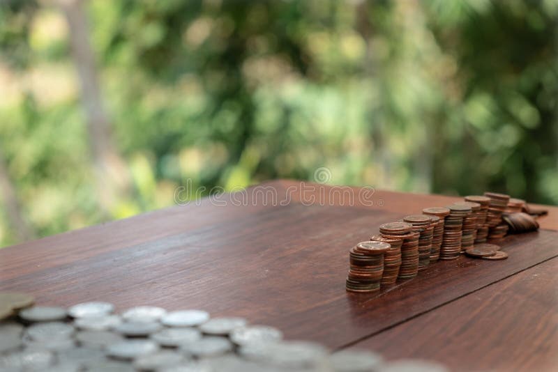 Thailändska lotter för satang för badmynt 25 på trätabellen med suddig bakgrund, pengar av det Thailand, investering- och bespari royaltyfria foton Thailändska lotter för satang för badmynt 25 på trätabellen med suddig bakgrund, pengar av det Thailand, investering- och bespari royaltyfria foton