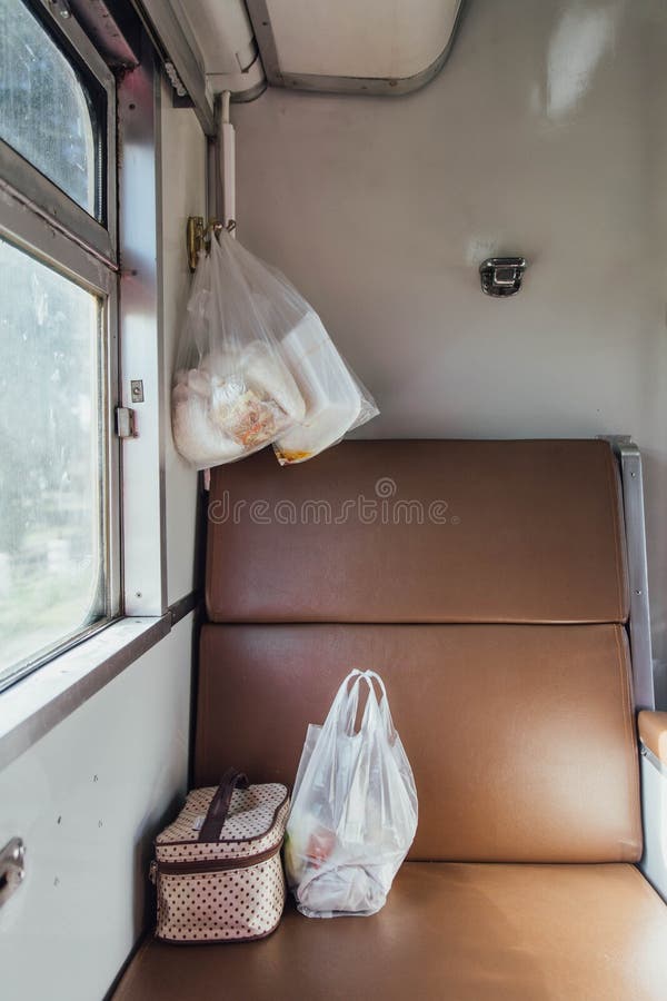 Thaise Trein Seat die dichtbij het Venster met Voedsel in Plastic Zakken en Stof in zakken doet royalty-vrije stock afbeeldingen Thaise Trein Seat die dichtbij het Venster met Voedsel in Plastic Zakken en Stof in zakken doet royalty-vrije stock afbeeldingen