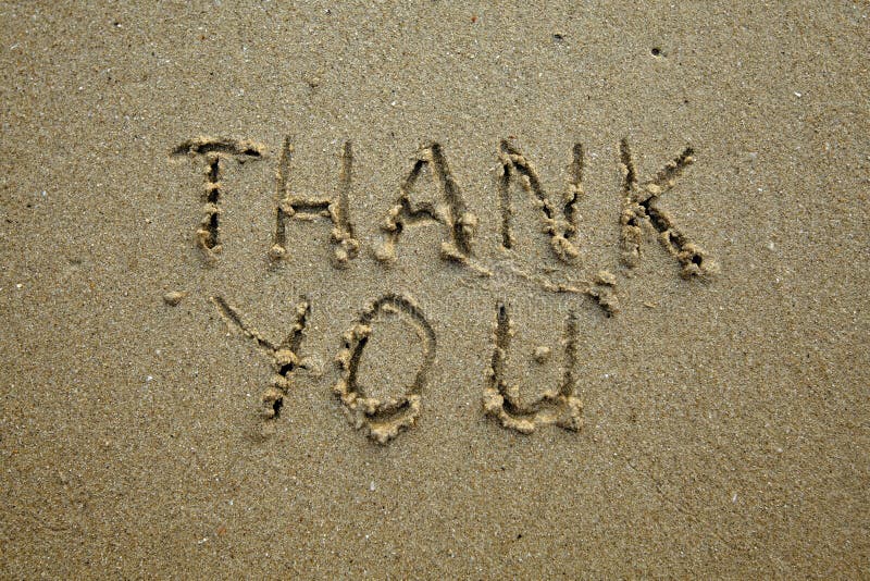 Thank you â€“ handwritten inscription on the soft beach sand.