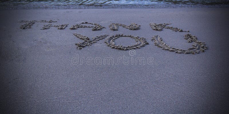Thank you message written in sand