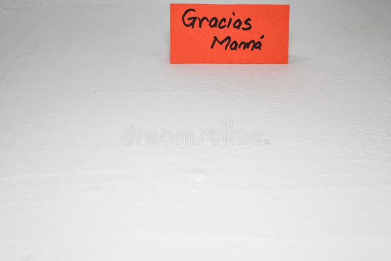 Thank you mom in Spanish gracias mama writing love text for mother on paper. Label tag with lovely message for mother`s day.  royalty free stock photo