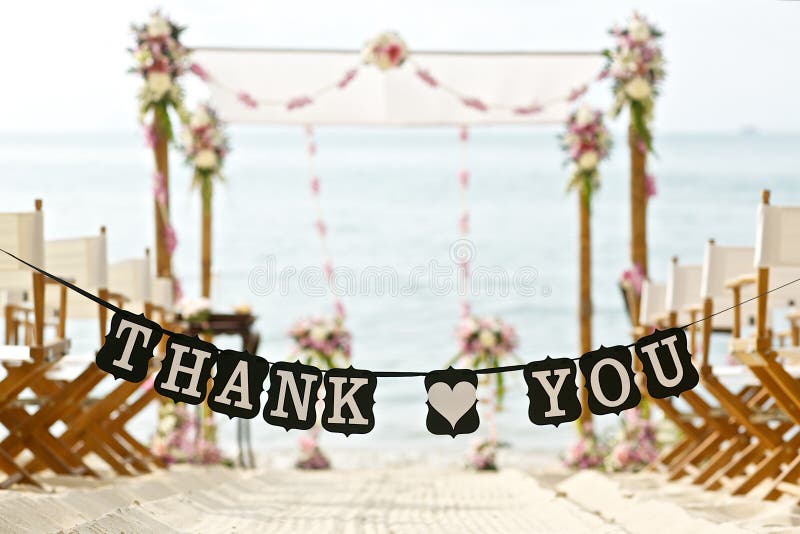 Thank you words banner at beautiful beach wedding set up chairs