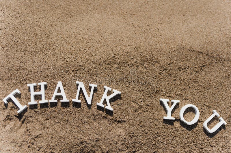 Thank you word drawn on the beach sand