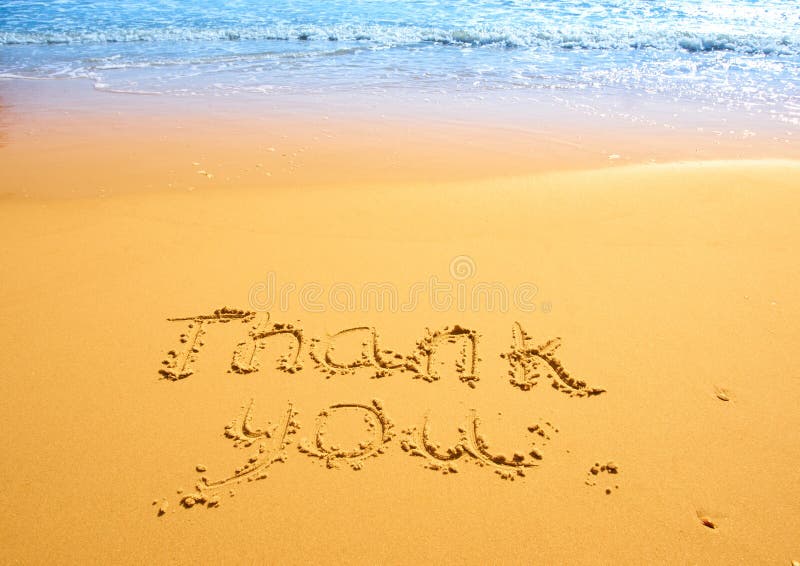 Thank you written in the sand on the beach