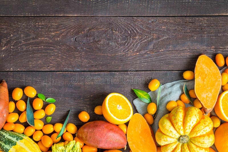 Thanksgiving Autumn Background, Variety of Orange Fruits and Vegetables on Dark Wooden Background with Free Space for Text