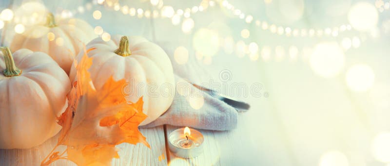 Thanksgiving background. Wooden table, decorated with pumpkins, autumn leaves and candles