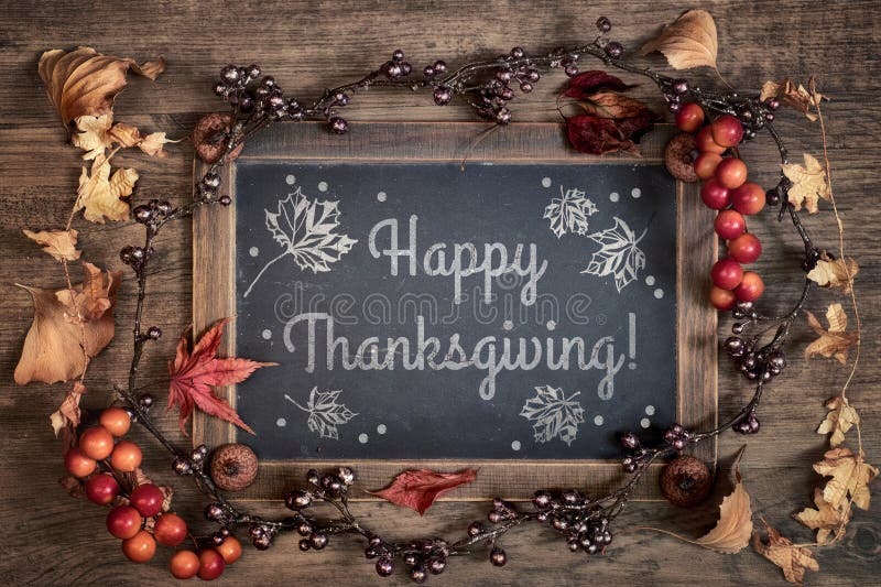 Blackboard with greeting `Happy Thanksgiving` with Autumn decorations on wood. Top view, toned image. Text greeting stock images, royalty-free photos and pictures