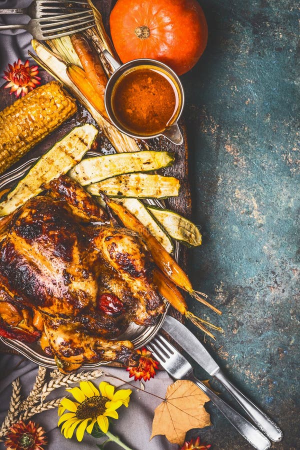 Thanksgiving dinner with roasted turkey ,sauce,grilled vegetables,corn ,cutlery , pumpkin, fall leaves and flowers arrangements, royalty free stock image Thanksgiving dinner with roasted turkey ,sauce,grilled vegetables,corn ,cutlery , pumpkin, fall leaves and flowers arrangements, royalty free stock image