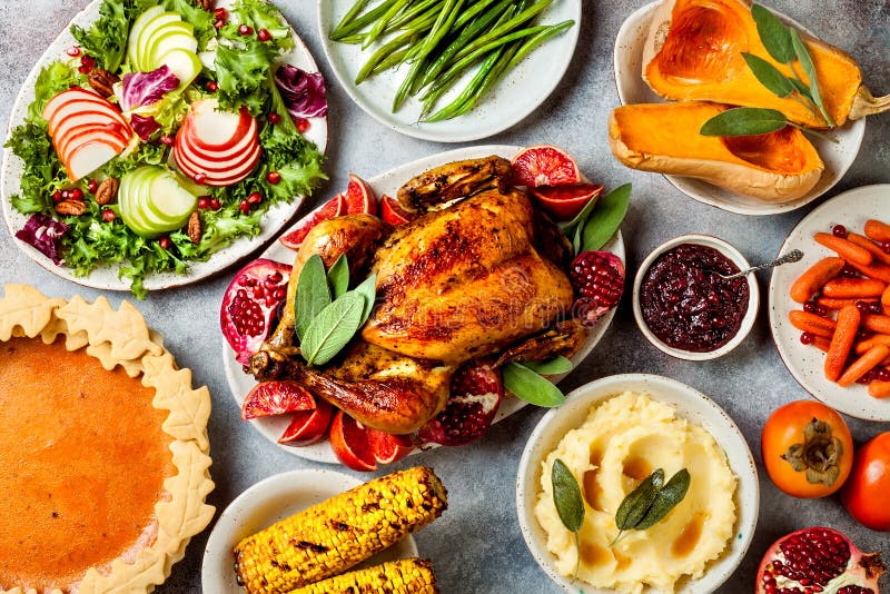Thanksgiving dinner table with roasted whole chicken or turkey, green beans, mashed potatoes, cranberry sauce, grilled vegetables. Thanksgiving dinner table with royalty free stock photo