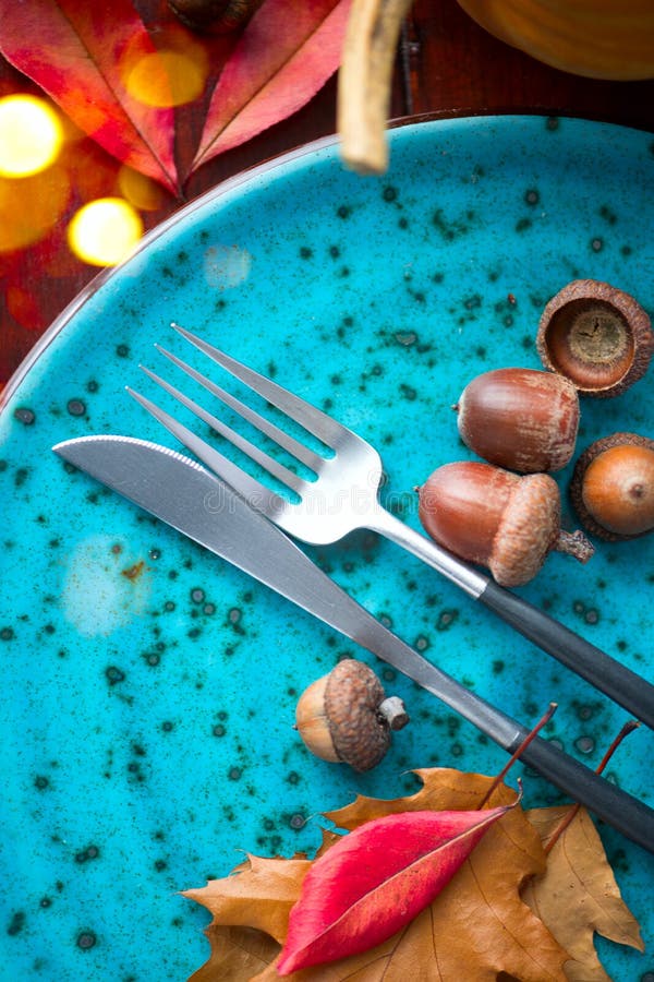 Thanksgiving Dinner. Thanksgiving wooden table served, decorated with bright autumn leaves, pumpkin and acorns. Holiday Table