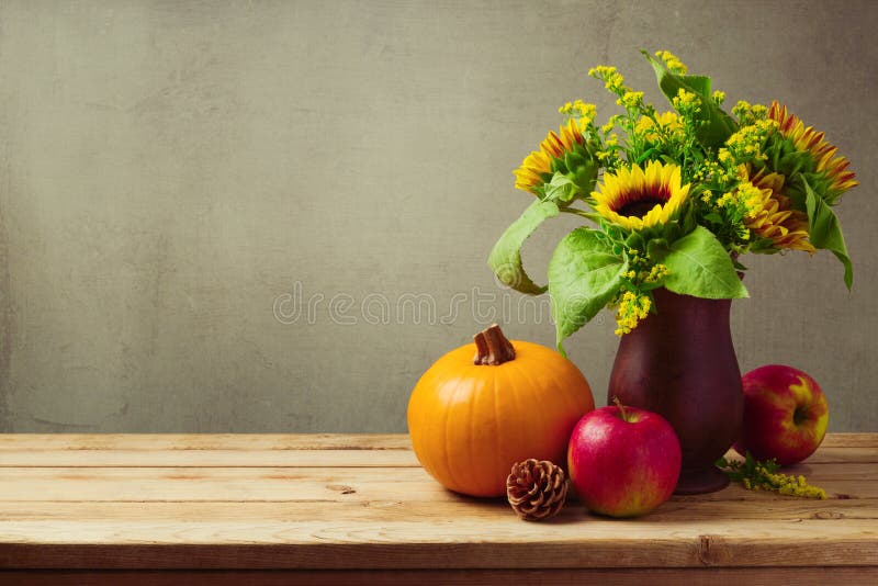 Thanksgiving holiday table decoration with sunflowers, pumpkin and apples