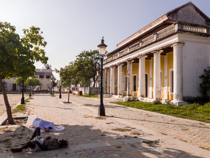 Tharangambadi, Tamil Nadu, India - January 2017: People resting in the shade on a quiet street with vintage architecture in the former Danish colony of Tranquebar