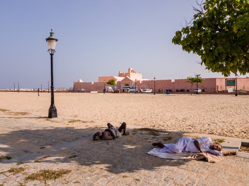 Tharangambadi, Tamil Nadu, India - January 2017: People resting in the shade on the sand outside the ancient Fort Dansborg in the former Danish colony of Tranquebar