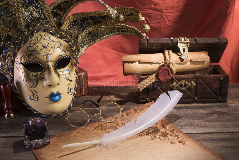 Theater concept. Vintage still life with quill and scroll near mask, old chest and glasses on red background