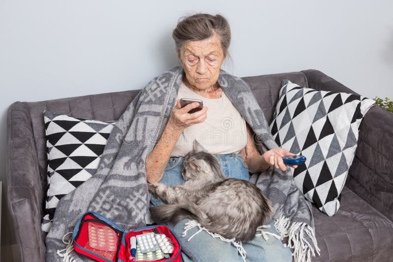 Theme old man and diabetes. older Caucasian woman with gray hair wrinkle home on sofa measures glucose level blood with stock image Theme old man and diabetes. older Caucasian woman with gray hair wrinkle home on sofa measures glucose level blood with stock image