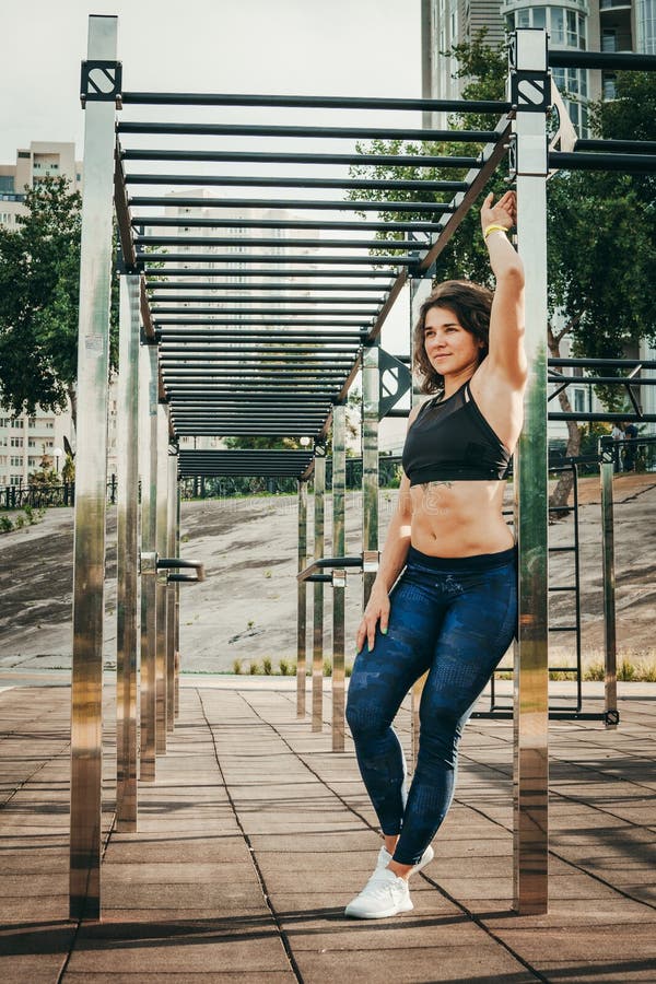 The theme women sports and health. Beautiful caucasian woman with curly long hair posing on outdoor sports ground holding hor royalty free stock images The theme women sports and health. Beautiful caucasian woman with curly long hair posing on outdoor sports ground holding hor royalty free stock images