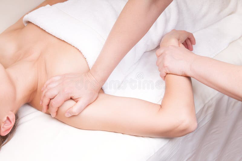 A qualified therapist doing a pressure point massage to relax a woman's shoulder. A qualified therapist doing a pressure point massage to relax a woman's shoulder