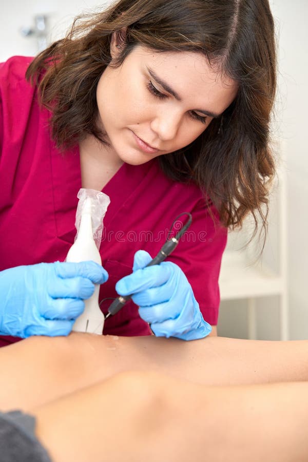 Therapist Performing a Percutaneous Electrolysis Procedure with an Ultrasound Machine on the