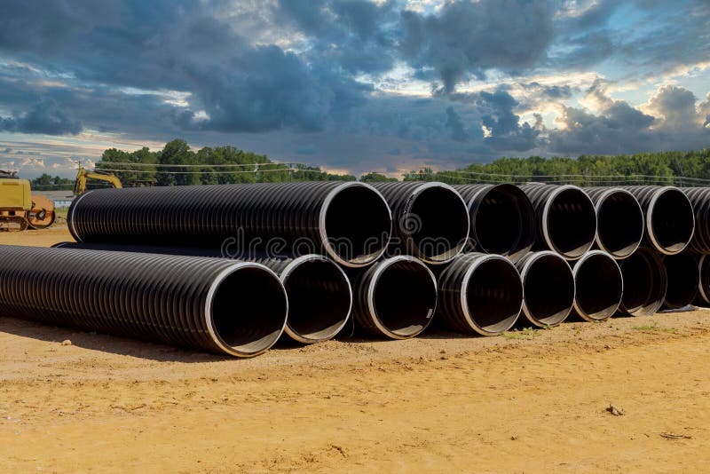 There are Rows of New Black Plastic PVC Pipes Stacked in Rows for Drain