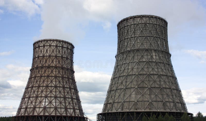 Thermal power station, cogeneration plant, two cooling towers from which smoke comes. Blue sky