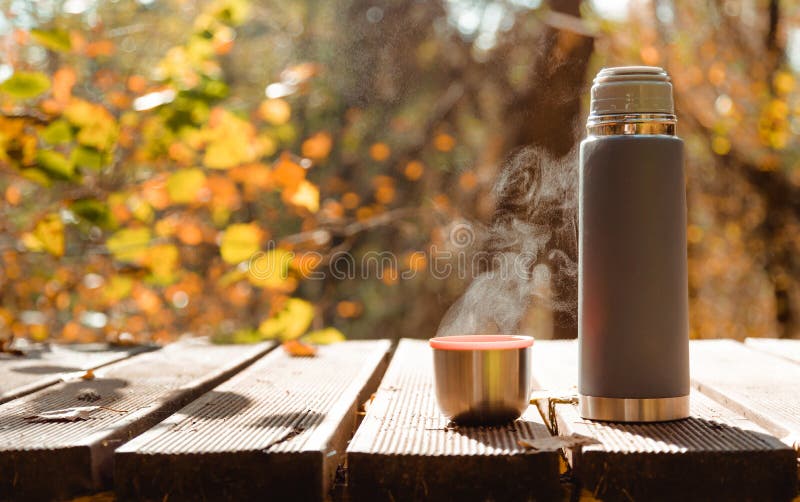 https://thumbs.dreamstime.com/b/thermos-mug-steaming-tea-wooden-table-autumn-forest-hot-beverages-hiking-trip-259930962.jpg