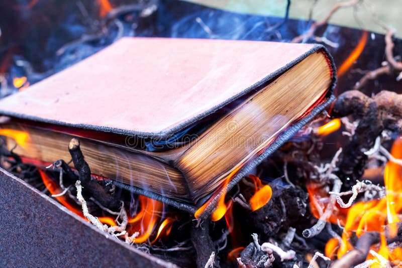 A thick book on fire. Burning books. Destruction of banned books