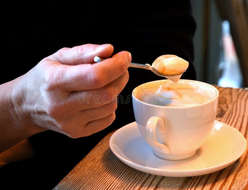 Thick Coffee Foam on a Teaspoon with a Cup of Coffee Stock Photo