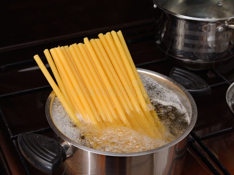 Thick Large Pasta is Cooked in an Iron Pot with Boiling Water. on a