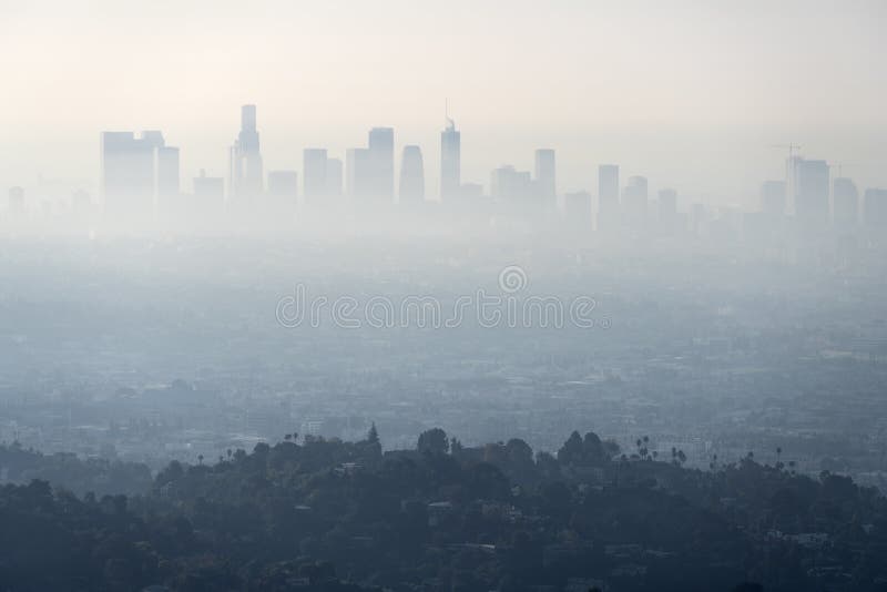 Thick layer of smog and haze from nearby brush fire obscuring the view of downtown Los Angeles buildings in Southern California.   Shot from hilltop in popular Griffith Park. Thick layer of smog and haze from nearby brush fire obscuring the view of downtown Los Angeles buildings in Southern California.   Shot from hilltop in popular Griffith Park.