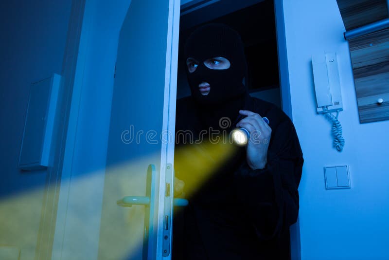 Thief holding flashlight while entering into house royalty free stock image Thief holding flashlight while entering into house royalty free stock image