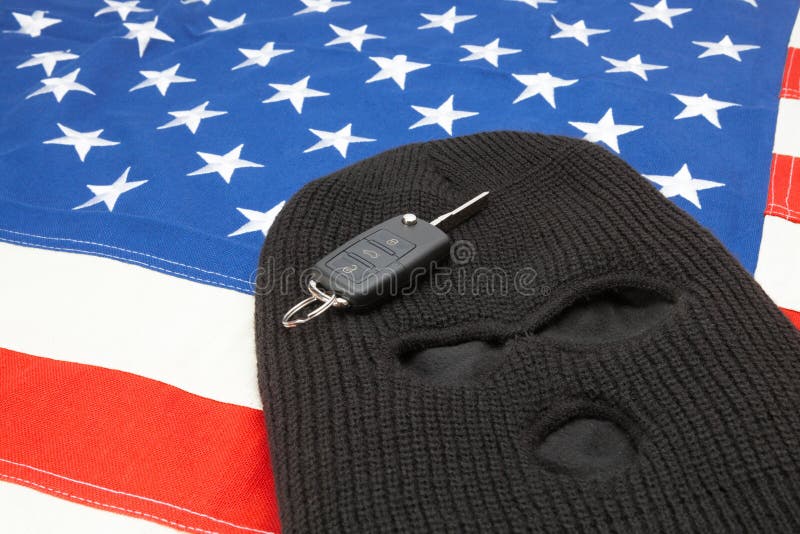 Thief mask with car keys over US flag