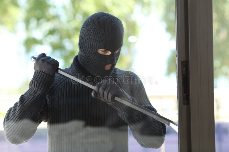 Thief trying to open a house window