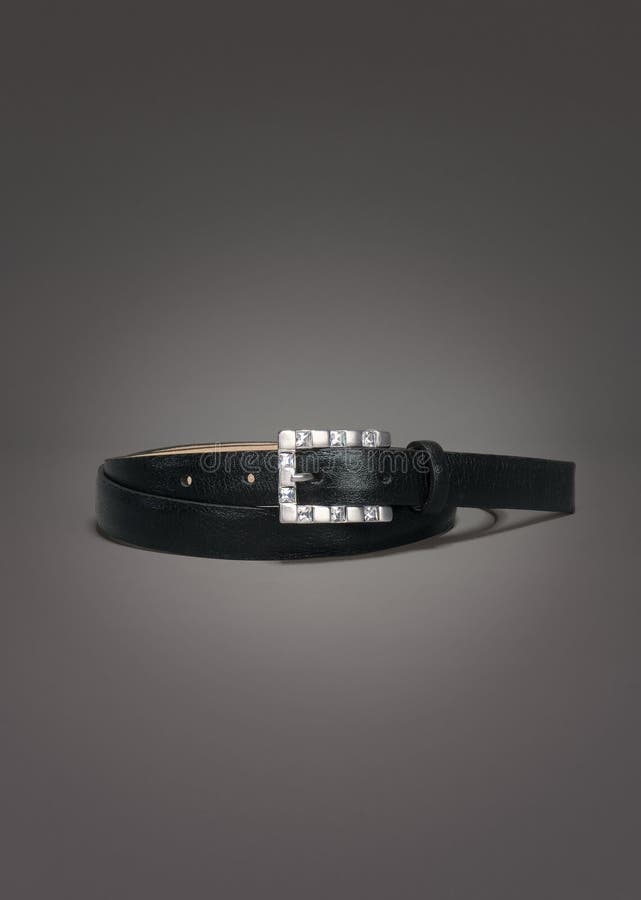 Thin black leather belt with gemstones buckle on gradient gray background royalty free stock photo Thin black leather belt with gemstones buckle on gradient gray background royalty free stock photo