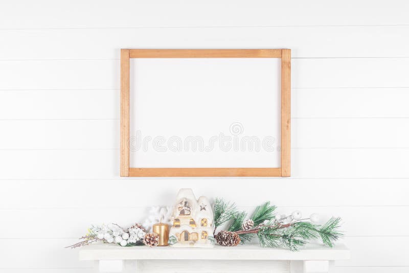 Thin light wood frame on mantelpiece with spruce branches