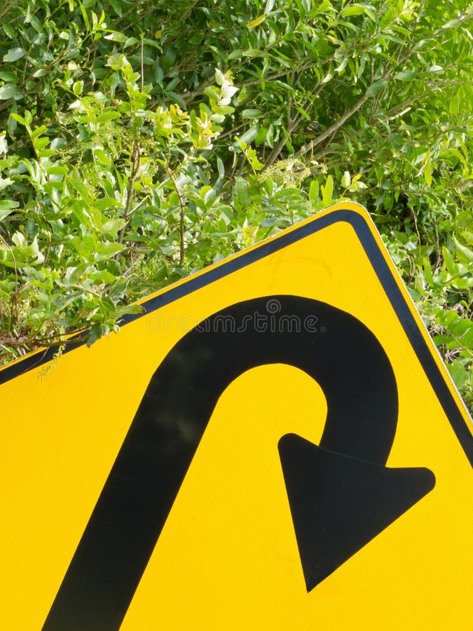 Think green - U-turn roadsign in lush vegetation royalty free stock photo
