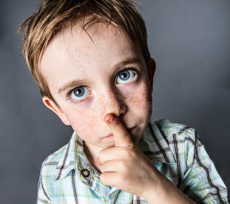 Thinking beautiful young boy with big blue eyes looking up