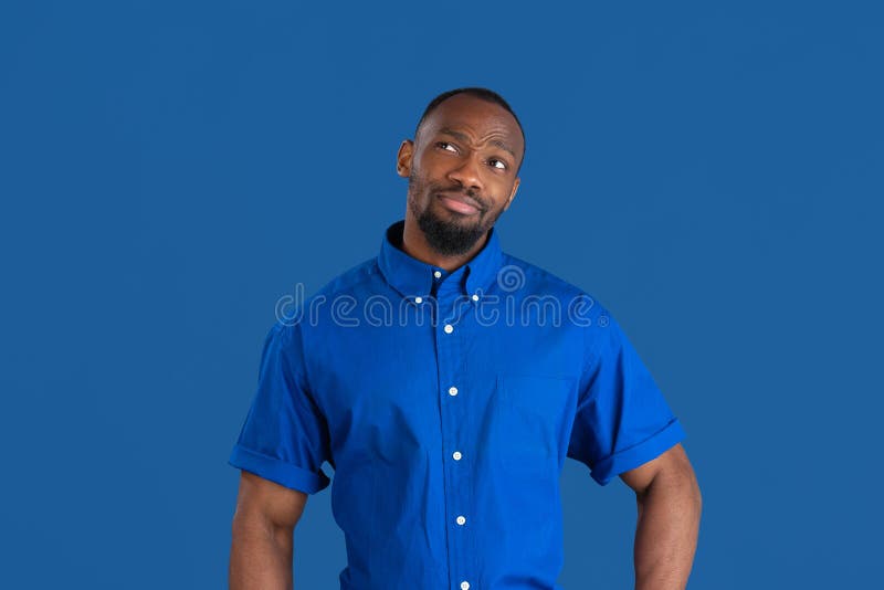 Monochrome portrait of young african-american man on blue studio background